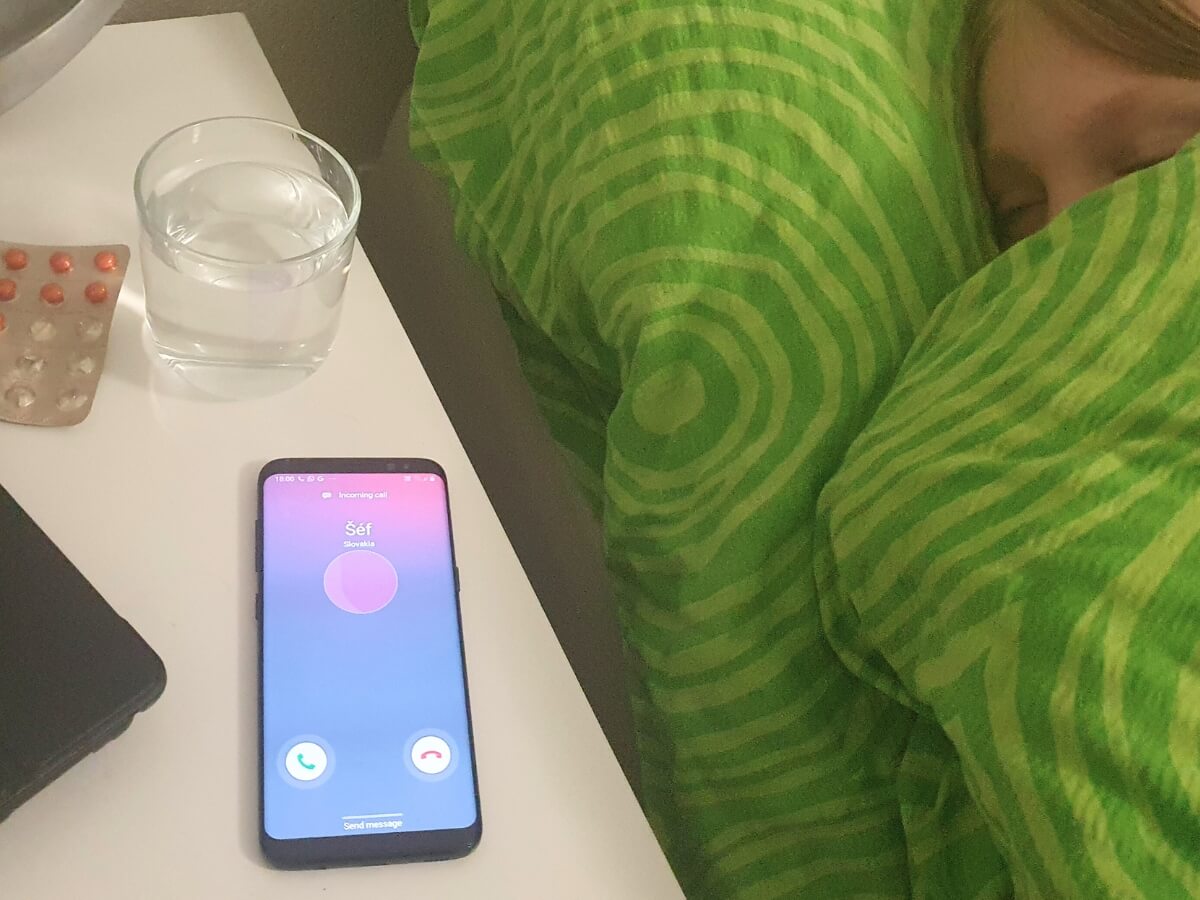 Žena spiaca v posteli a zvonenie telefónu.